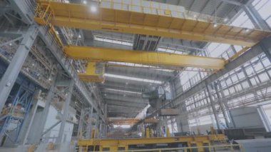 Elektromanyetik mıknatıslı sarı vinç. Elektromanyetik mıknatısı olan sarı bir vinç sıcak metali hareket ettirir. Modern bir atölyede bir vinç..
