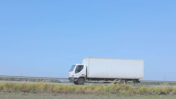 El vagón conduce a lo largo de una hermosa carretera en verano. Una carreta monta un camino contra un cielo azul — Vídeo de stock
