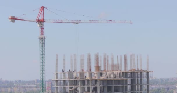 Turmdrehkran auf einer Baustelle. Baukran auf einer Baustelle. Bau eines mehrstöckigen Wohnhauses. — Stockvideo