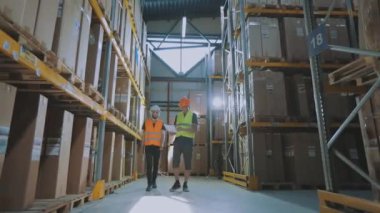 Modern bir depoda iki mühendis. Depoda iki kişi bir şey tartışıyor..