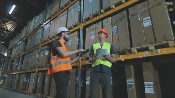 Dva dělníci půjdou do moderního skladiště. pracovní proces ve skladu. Moderní továrna, průmyslový interiér — Stock video