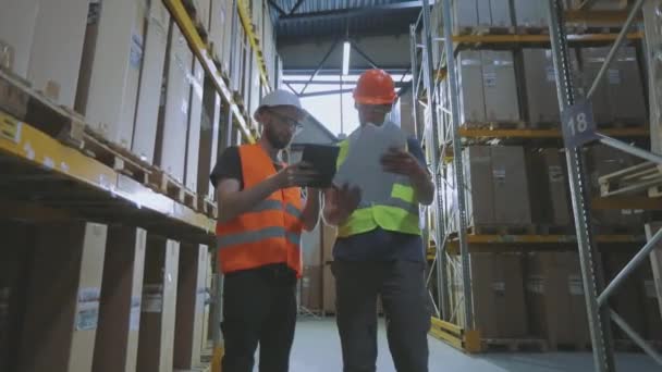 Dos personas en el almacén están discutiendo algo. Dos ingenieros en un almacén moderno. — Vídeo de stock