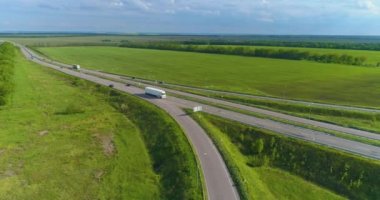 Araba manzaralı bir yol. Şehrin dışındaki otoyol, yolun kenarındaki tarlalar.