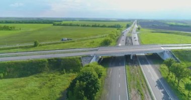 Trafik kavşağı üst görünümü değiştir. Otoyol manzaralı bir yer. Yol ayrımının üzerinden uçuyor. Arabalar şehrin dışındaki otoyol boyunca gider.