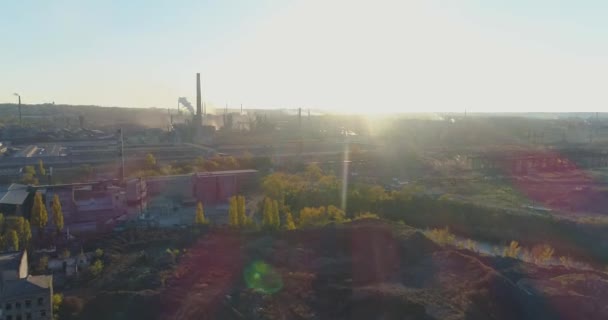 Rook uit de schoorsteen van een fabriek bij zonsondergang vanuit de lucht. Metallurgische fabriek bij zonsopgang bovenaanzicht. Industriezonezicht. — Stockvideo