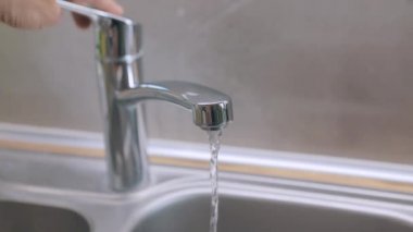 Muslukta su içmek. Karıştırıcı yakın plan. Musluktan musluk suyu akar. Mutfaktaki musluk yakın plan..