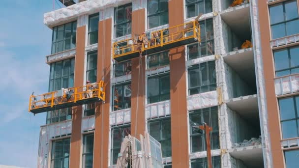 O guindaste levanta janelas de vidros duplos. Um guindaste levanta janelas para instalação em um edifício residencial. Trabalho na construção de casa — Vídeo de Stock