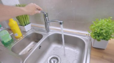 Musluktan yavaş çekimde su akar. Musluktan musluk suyu akar. Muslukta su içmek. Mutfağa yakın çekim musluğu. Karıştırıcı yakın plan