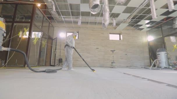 コンクリート表面研削。建設現場の建築家。建築家は特別な設備で床を研磨しています. — ストック動画
