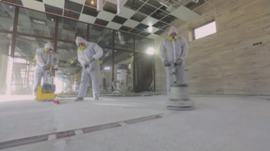 Profesyonel ekipmanlı inşaatçılar. Çizgiye çalış. Üniformalı inşaatçılar. İnşaatçılar beton döşeme yapıyorlar..