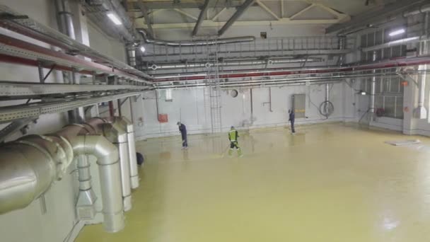 Workers make the floor in the workshop of the plant. Workers at the construction site. Construction of a new workshop at the plant — Stock Video