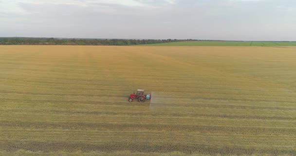 Postřikování pole s pšeničným výhledem z dronu. Traktor rozstřikuje pšenici herbicidy. Traktor stříká pšeničná pole. — Stock video