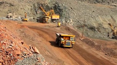 Demir madenini açık bir çukura boşaltmak için gerekli ekipman. Demir cevheri ocağındaki akıllı işlem. Taş ocağındaki bir kazıcı bir çöp kamyonuna toprak yüklüyor. Taş ocağında demir cevheri çıkarma işlemi.