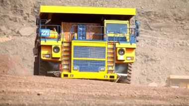 Kömür madeninde büyük bir çöp kamyonu. Büyük bir maden kamyonu. Kömür madenindeki sarı çöp kamyonu. Çöp kamyonu taş ocağından geçiyor..