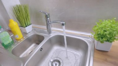 Musluktan yavaş çekimde su akar. Musluktan musluk suyu akar. Muslukta su içmek. Mutfağa yakın çekim musluğu. Karıştırıcı yakın plan