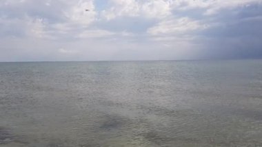 Sakin deniz, arka planda fırtına bulutları.