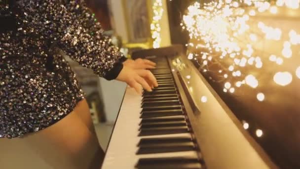 Κοντινό πλάνο των χεριών που παίζουν το συνθεσάιζερ. Το κορίτσι παίζει το συνθεσάιζερ. Συνθεσάιζερ με χριστουγεννιάτικα στολίδια close-up — Αρχείο Βίντεο