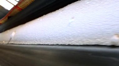 Topraklı taşıma bandı. Bir fabrikada toplu malzeme taşıyan taşıyıcı bant. Beyaz malzeme içeren taşıyıcı bant