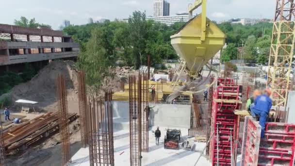 Lavoratori in un cantiere. Costruzione di strutture in cemento armato. Costruzione di un moderno complesso residenziale — Video Stock