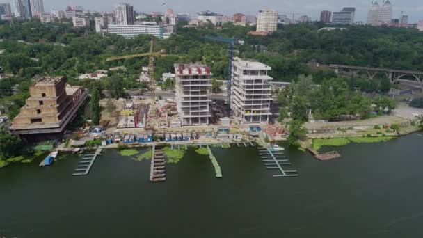 Construcción de un complejo residencial cerca del río. Construcción de un edificio de apartamentos en la orilla del río — Vídeos de Stock