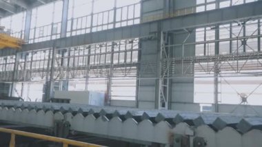 Elektromanyetik mıknatıslı sarı vinç. Elektromanyetik mıknatısı olan sarı bir vinç sıcak metali hareket ettirir. Modern bir atölyede bir vinç..