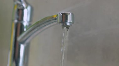 Musluktan musluk suyu akar. Muslukta su içmek. Mutfağa yakın çekim musluğu. Karıştırıcı yakın plan