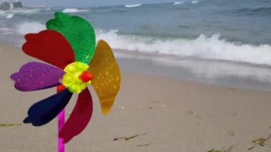 Rüzgardaki bir çocuk yel değirmeni, deniz kıyısındaki rüzgardan dönen renkli bir çocuk değirmeni. Çocuklar denizdeki yel değirmeni