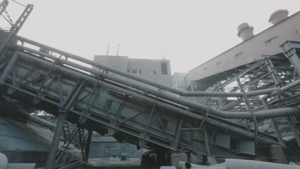 Un homme dans une usine métallurgique. Un ouvrier traverse une grande usine. Structures métalliques massives dans une usine métallurgique — Video