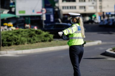 Bükreş, Romanya - 18 Ekim 2020: Kadın polis memuru, sürücülerin covid karşıtı tedbirlere uyup uymadığını kontrol etmek için araçları trafikte kenara çekti.