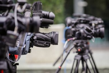 Bükreş, Romanya - 25 Ekim 2020: Sokakta düzenlenen bir basın etkinliğinde tripodlara televizyon kameraları yerleştirilmiş sığ alan derinliği (seçici odak).
