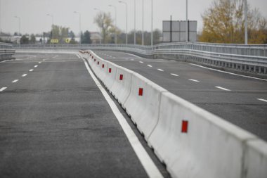 Beton Jersey bariyerleriyle (Jersey duvarları veya Jersey tümsekleri) bir otoyolda sığ alan derinliği (seçici odak) görüntüsü.
