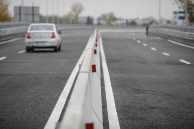 Beton Jersey bariyerleriyle (Jersey duvarları veya Jersey tümsekleri) bir otoyolda sığ alan derinliği (seçici odak) görüntüsü.