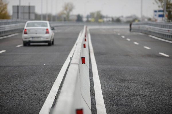 Shallow depth of field (selective focus) image with concrete Jersey barriers (Jersey walls or Jersey bumps) on a highway.