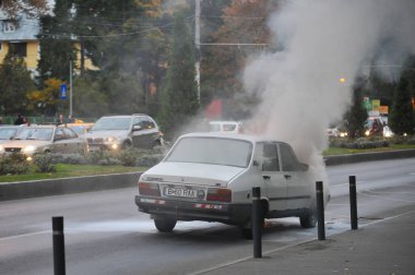 Bükreş, Romanya - 3 Kasım 2011: Eski Dacia arabası caddenin ortasında alev aldı.