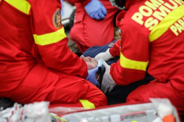 Bükreş, Romanya - 5 Aralık 2020: Romen Ambulansı 'ndan (SMURD) sağlık görevlileri bir araba kazası kurbanını kurtardı.