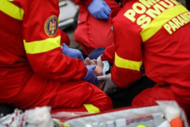 Bükreş, Romanya - 5 Aralık 2020: Romen Ambulansı 'ndan (SMURD) sağlık görevlileri bir araba kazası kurbanını kurtardı.