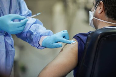 Bükreş, Romanya - 4 Ocak 2021: Sığ alan derinliği (seçici odak) görüntüsü, Pfizer BioNTech aşısının tıbbi personel aşısı sırasında hastanede yer alması.