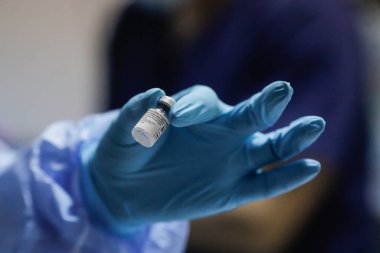 Bükreş, Romanya - 4 Ocak 2021: Sığ alan derinliği (seçici odak) görüntüsü, Pfizer BioNTech aşısının tıbbi personel aşısı sırasında hastanede yer alması.