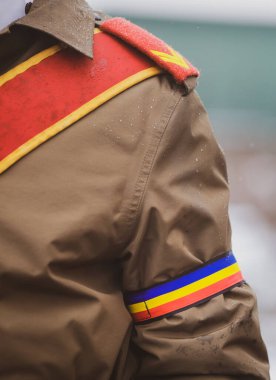 Soğuk ve karlı bir kış gününde düzenlenen resmi törende bir Romen askerinin üniformasıyla sığ alan derinliği (seçici odak)..