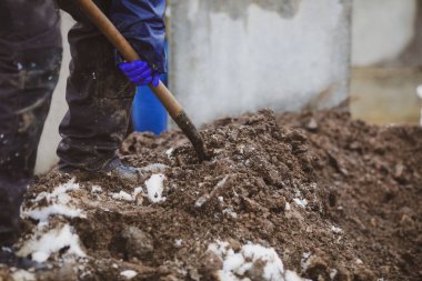 Soğuk ve karlı bir kış gününde defin töreninde mezarı kürekle pislikle kaplayan bir mezar kazıcının detayları..