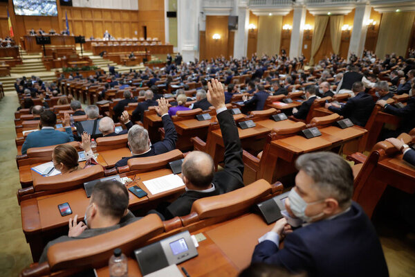 Бухарест, Румыния - 17 февраля 2021 года: Глубокая полевая глубина (избирательный фокус) с деталями голосования румынских депутатов, подняв руки.