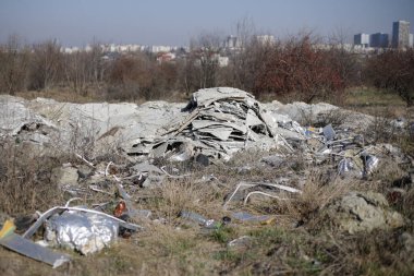 Bükreş 'teki boş bir arsaya, derme çatma bir barınağın yakınına saçılmış çöp ve inşaat atıklarının sığ derinliği.