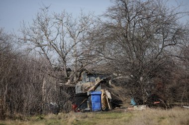 Bükreş 'teki boş bir arsaya, derme çatma bir barınağın yakınına saçılmış çöp ve inşaat atıklarının sığ derinliği.