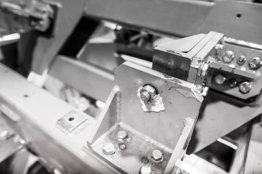 Ağır bir fabrikada endüstriyel metal ceviz ve cıvataların detaylarıyla sığ alan derinliği (seçici odak) görüntüsü.