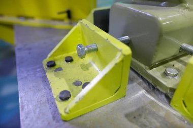 Ağır bir fabrikada endüstriyel metal ceviz ve cıvataların detaylarıyla sığ alan derinliği (seçici odak) görüntüsü.