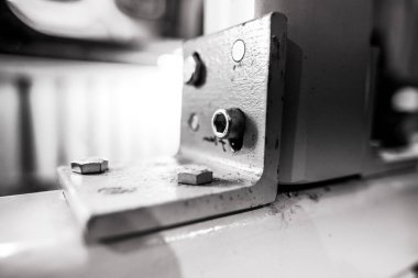 Ağır bir fabrikada endüstriyel metal ceviz ve cıvataların detaylarıyla sığ alan derinliği (seçici odak) görüntüsü.