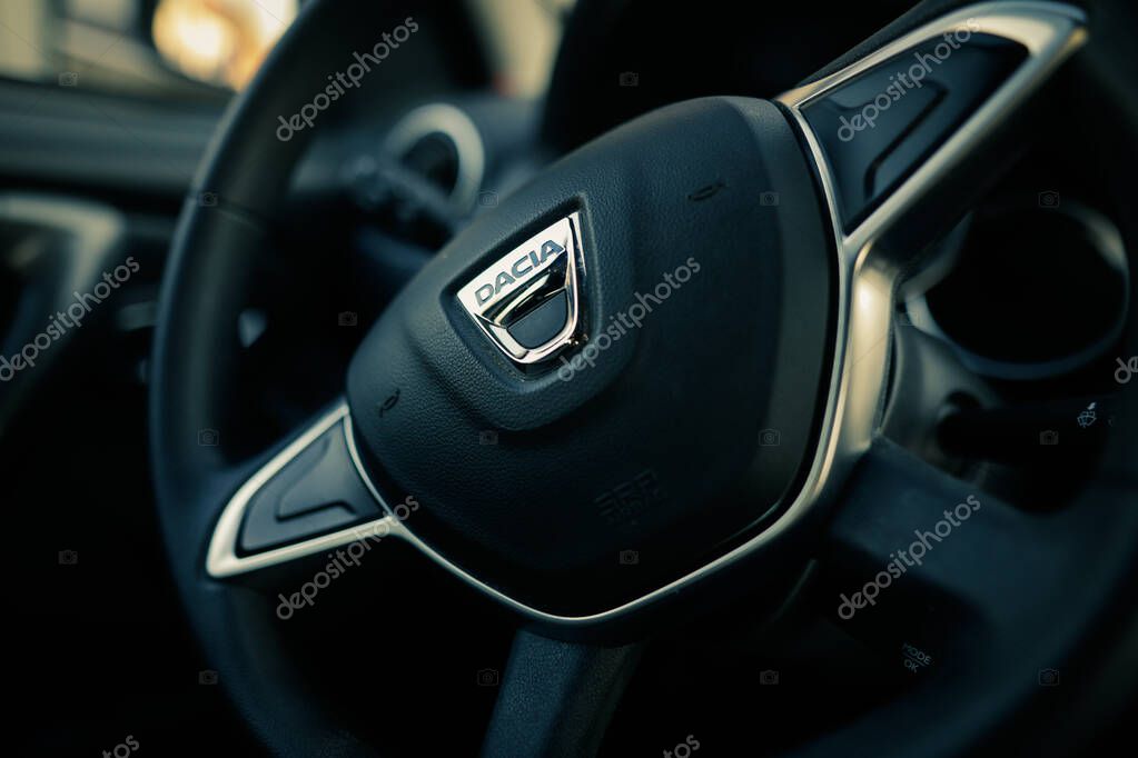 Bucharest, Romania - April 11, 2021: Shallow depth of field (selective focus) image with the Dacia logo on a Duster steering wheel.