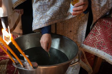Vaftiz sırasında kilisede bir ortodoks rahiple sığ alan derinliği (seçici odak) ayrıntıları.