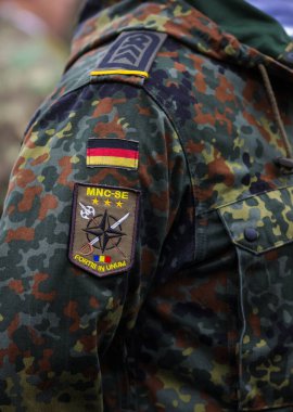 Bükreş, Romanya - 1 Aralık 2025: Romanya Ulusal Günü askeri geçidine katılmaya hazırlanan bir Alman askerinin üniformasına yama.