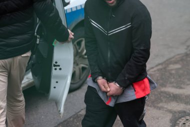 Bükreş, Romanya - 29 Ocak 2026: Romen polisleri tarafından tutuklanan kelepçeli bir adamla ilgili ayrıntılar.